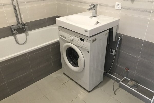Wasmachine onder de gootsteen in de badkamer