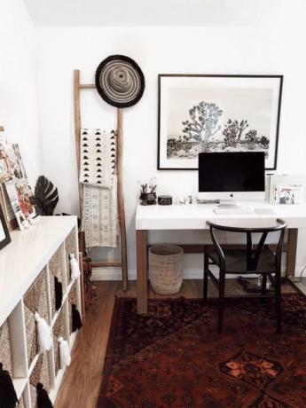 Boho Scandi thuisstudie met boho-tapijt, manden, bedrukt textiel en kwastjes en stevige witte tafel