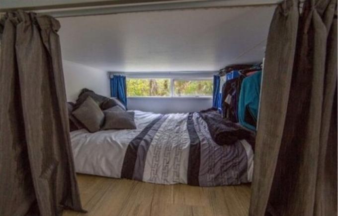 Mini-slaapkamer met een groot bed.