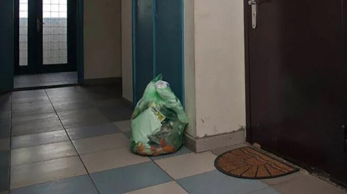 Umnichka vrouw, gespeend buren staan ​​vuilniszak in de gemeenschappelijke gang, nu de afvalstoffen niet ruiken!